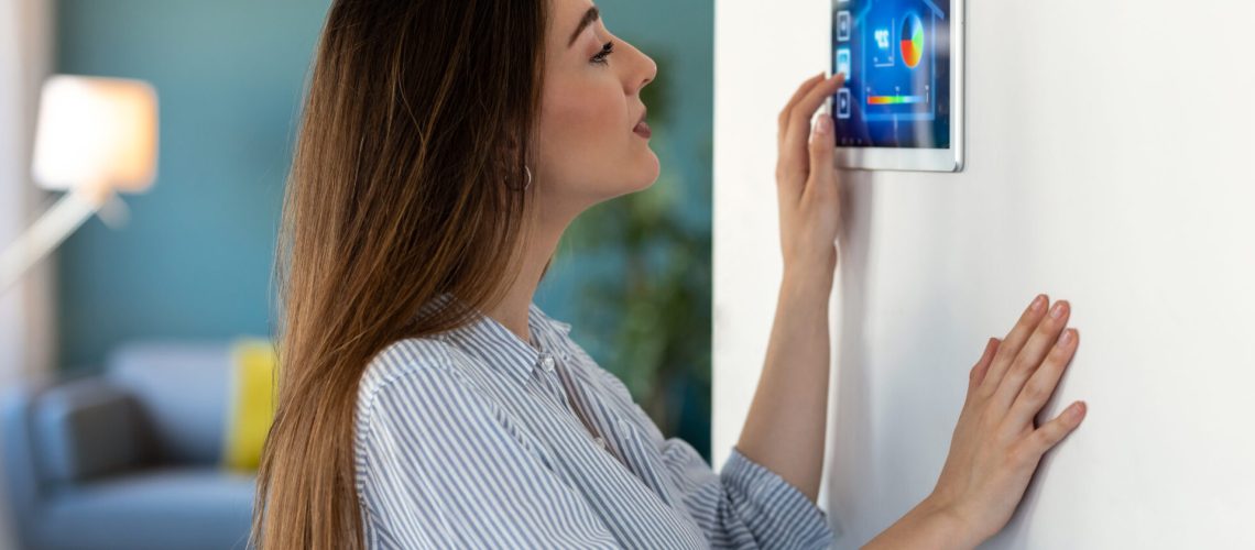 Shot of pretty young woman using the home automation system on digital tablet to regulate the temperature.